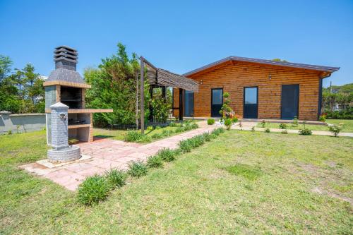 a log cabin with a garden and a brick walkway at The Sea House Velipoje in Velipojë