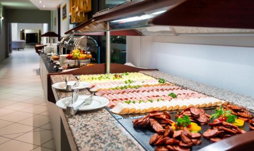 una línea de buffet con muchos tipos diferentes de pasteles y carnes en Hotel Millennium, en Budapest