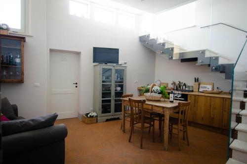 a living room with a table and a staircase at Dimora Dell'Erbe Apartment in Montepulciano