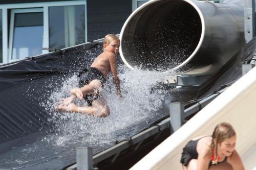 a young boy playing on a water slide at Løkken Klit Camping (Empty Lot) in Løkken