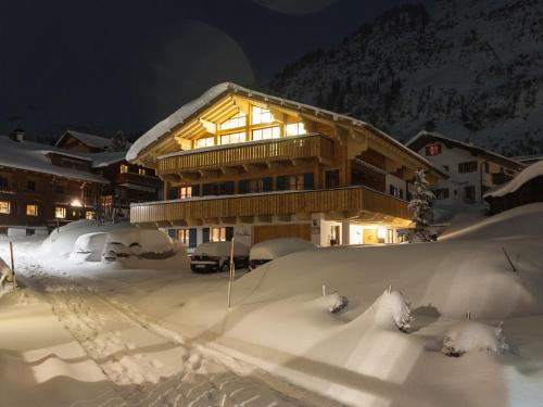 a building covered in snow at night at Appartements Täli in Lech am Arlberg