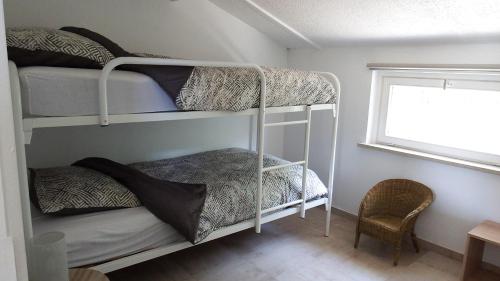 a bedroom with two bunk beds and a window at a l'aise aan zee in Koksijde