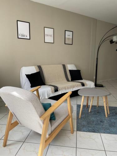 a living room with a couch and a table at Appartement Les 7 Roses in Vitry-le-François