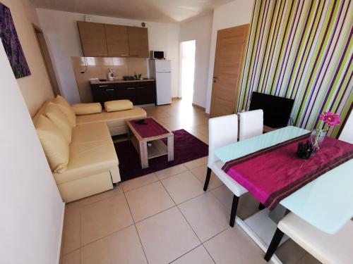 uma sala de estar com um sofá e uma mesa em Apartments Jadranka em Zadar