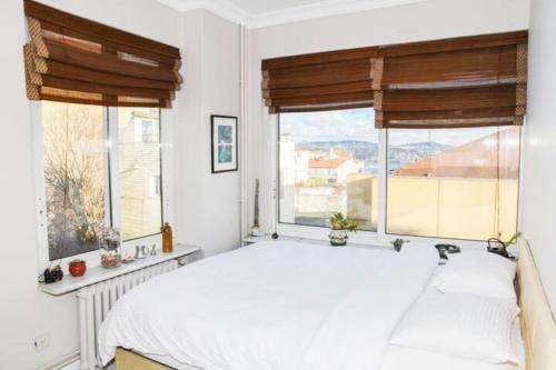 sypialnia z białym łóżkiem i 2 oknami w obiekcie Wonder Homes- Spectacular View 6BR, 2BA, Rooftop w Stambule