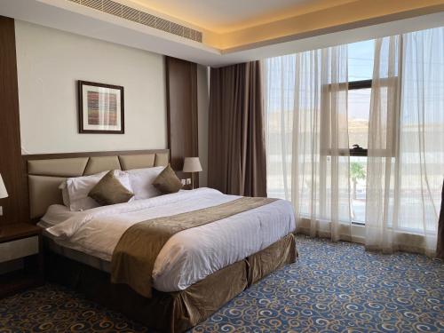 Habitación de hotel con cama y ventana grande en فندق ضيافة القرية Al Diyafa Hotel en Al Ahsa