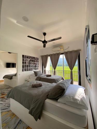 LamanLeman Langkawi في بانتايْ سينانج: غرفة نوم بسريرين ومروحة سقف