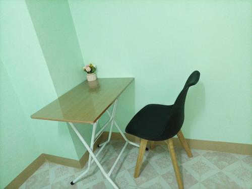 una silla negra junto a un escritorio de madera en JATUPORN A2 en Ban Talat Rangsit