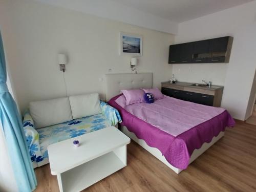 ein kleines Schlafzimmer mit einem Bett und einem Sofa in der Unterkunft Blaxy Resort STEFI in 23 August