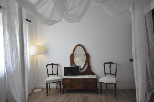 a room with a desk with a mirror and two chairs at B&B Casa Soresina in Offagna