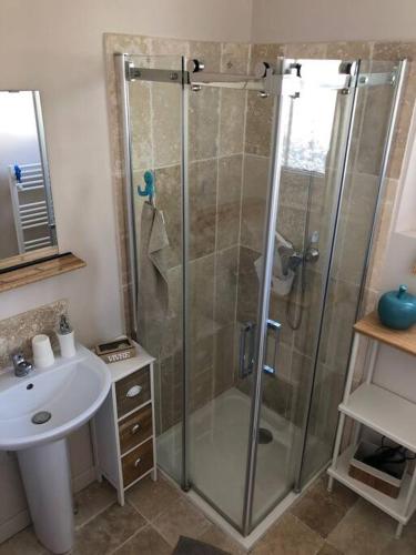 une salle de bain avec une douche en verre et un lavabo dans l'établissement AU FIL DE L EAU, à Menars