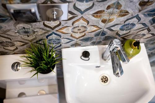 a bathroom with a sink and a potted plant at Domek Między Wodą in Międzywodzie