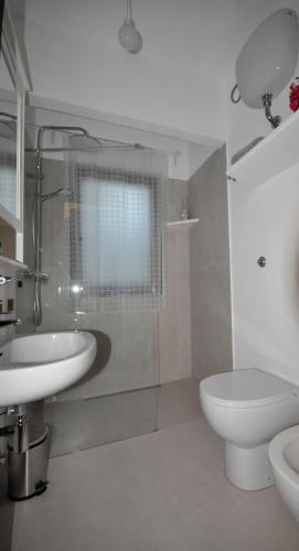 a white bathroom with a sink and a toilet at B&B Casa Soresina in Offagna