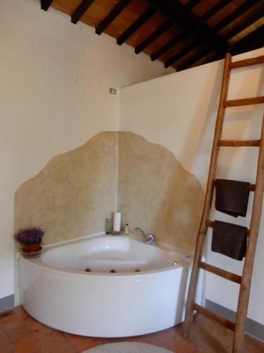 a white bath tub in a room with a ladder at Country Loft at Palazzo di Bagnaia in Castel del Piano