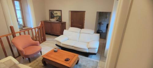 a living room with a white couch and a chair at Le gite d'aglae in Chémery