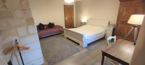 a small bedroom with a bed and a table at Le gite d'aglae in Chémery