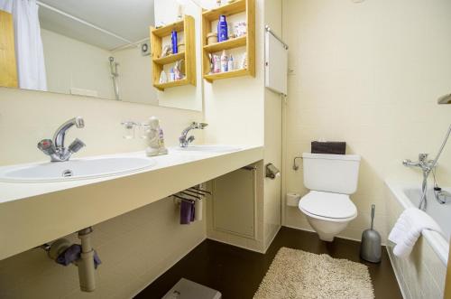 La salle de bains est pourvue d'un lavabo, de toilettes et d'un miroir. dans l'établissement Rothornblick 19, à Arosa