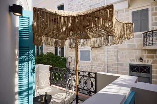 eine Terrasse mit Sonnenschirm auf dem Balkon in der Unterkunft Syroc Maison in Ermoupoli