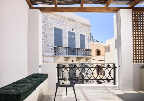a balcony with a green bench and a table at Syroc Maison in Ermoupoli