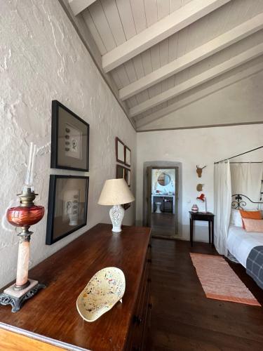 1 dormitorio con escritorio de madera, cama y lámpara en Convento Senhora da Vitória, en Castelo de Vide