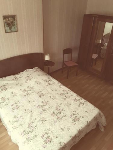 ein Schlafzimmer mit einem Bett, einem Stuhl und einem Spiegel in der Unterkunft L'ecole in Chuffilly-Roche