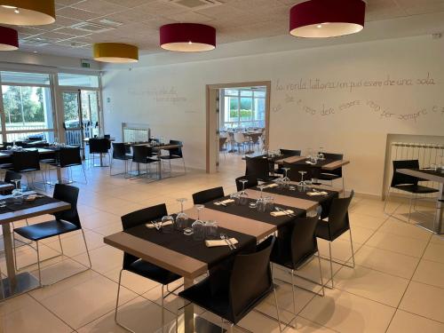a restaurant with tables and chairs in a room at Eliopoli Beach Hostel & Restaurant in Tirrenia