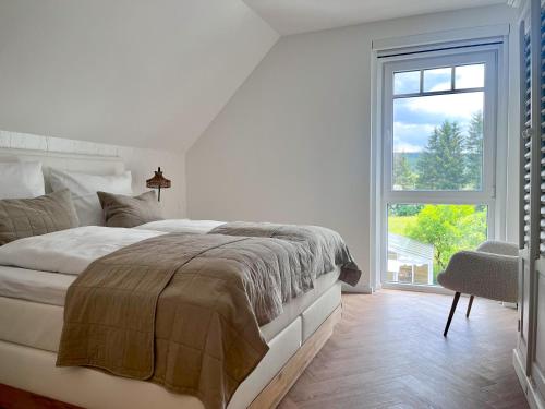 Dormitorio blanco con cama y ventana grande en Relaxhome, en Hallschlag