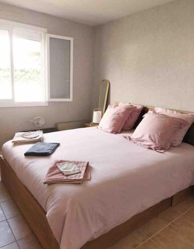 une chambre avec un grand lit blanc avec des oreillers roses dans l'établissement Maison de plein pied, 80m2, 2 ch., jardin clos, à Quiberon