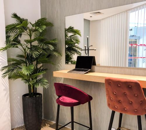 a kitchen with a desk with a laptop and two chairs at Hotel Apartamento Foz Atlantida in Monte Gordo