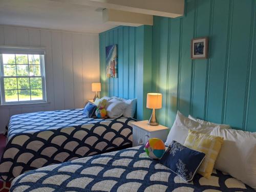 two beds in a room with blue walls at Surfside Inn Chatham in Chatham
