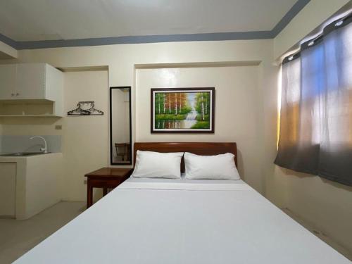 een slaapkamer met een groot wit bed en een wastafel bij Lawton Residences Studio Room 3E in Manilla