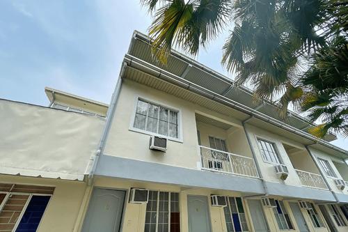 een wit huis met een balkon en een palmboom bij Lawton Residences Studio Room 3E in Manilla