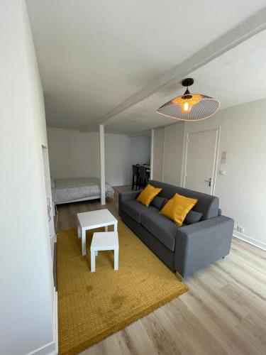 a living room with a couch and a table at Les 4 saisons Honfleur - Studio 2 in Honfleur