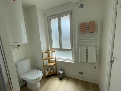 een witte badkamer met een toilet en een raam bij Les 4 saisons Honfleur - Studio 2 in Honfleur