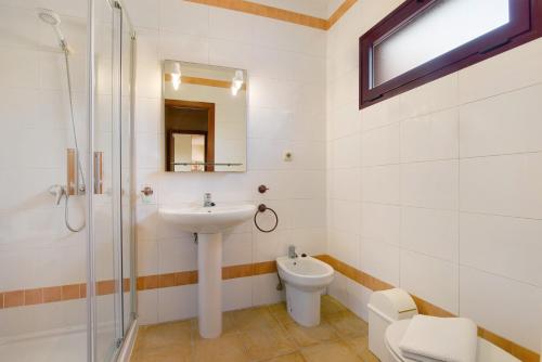 un baño con lavabo e inodoro en La Palmera de la Oliva, en La Oliva