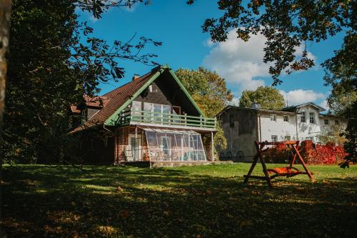uma casa antiga com um parque infantil no quintal em Pommernhof em Ustronie Morskie