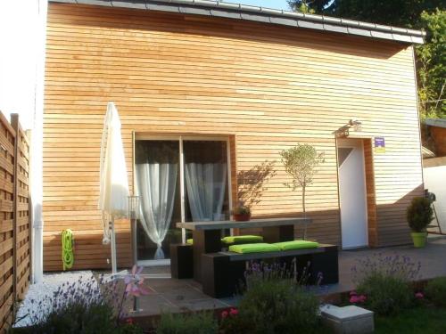 a patio with a couch and a table in front of a building at Gite de la buse in Sedan