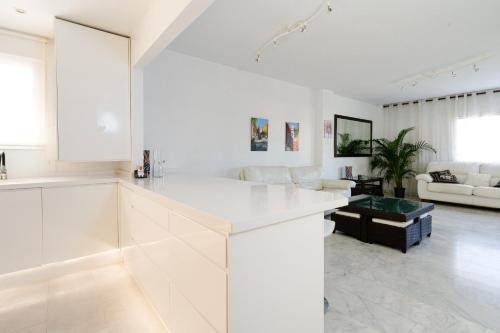 een keuken met witte kasten en een woonkamer bij Reserva de Marbella in Marbella