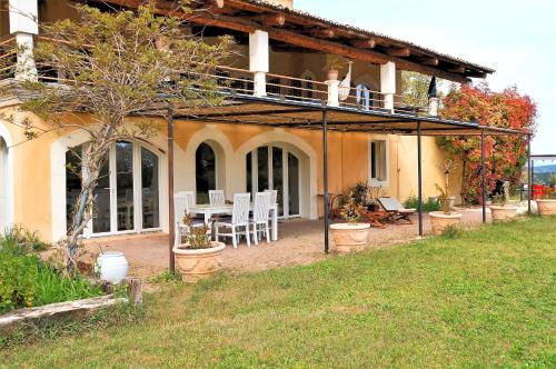 ein Haus mit einer Terrasse mit einem Tisch und Stühlen in der Unterkunft Appartement 5 personnes - Mas du Soleil in Bagnols-sur-Cèze