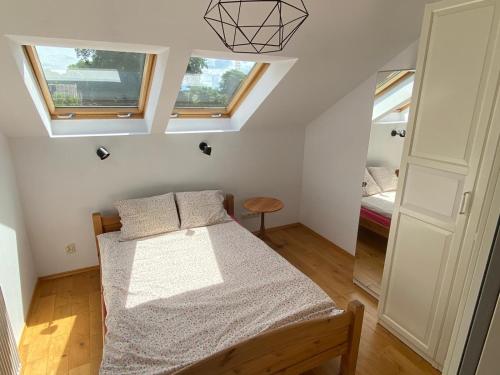 a bedroom with a bed and two windows at Apartament w Gdańsku Brzeźnie in Gdańsk