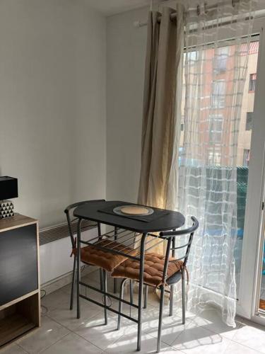 - une table et des chaises noires dans une chambre avec fenêtre dans l'établissement Studio Nice proche plages / université, à Nice
