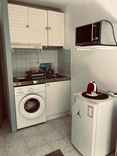 une cuisine avec un lave-linge et un micro-ondes dans l'établissement Studio Nice proche plages / université, à Nice
