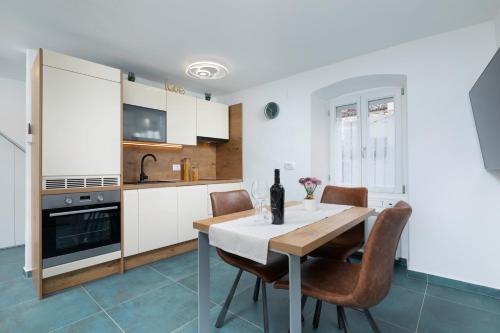 une cuisine avec une table et des chaises dans une pièce dans l'établissement Studio, 70 steps from the beach, à Baška