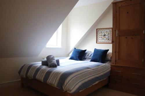 a bedroom with a bed with blue pillows at Beach Side Top Floor Property, Balcony & Sea Views in Newquay