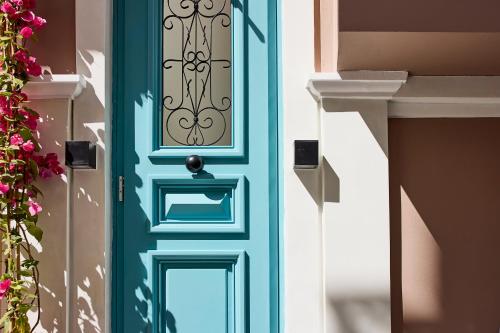 a blue door on a house with flowers at Syroc Maison in Ermoupoli