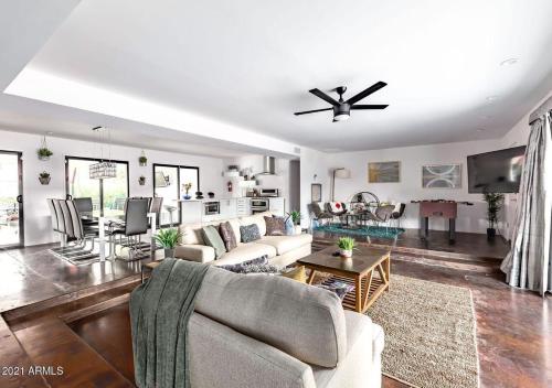 a living room with a couch and a ceiling fan at Designer 5 Bd Home, Fountain Pool, Spa, Game Patio in Phoenix