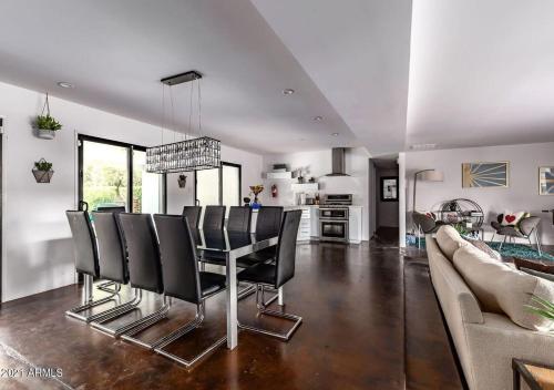 a dining room with black chairs and a table at Designer 5 Bd Home, Fountain Pool, Spa, Game Patio in Phoenix