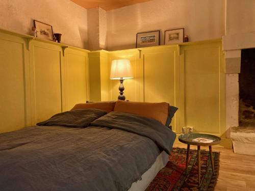 una camera da letto con un letto e un tavolo con una lampada di Encore une fois, La maison coloréé a Locmalo