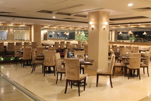 a restaurant with tables and chairs and a bar at Magnum Inn in Lahore