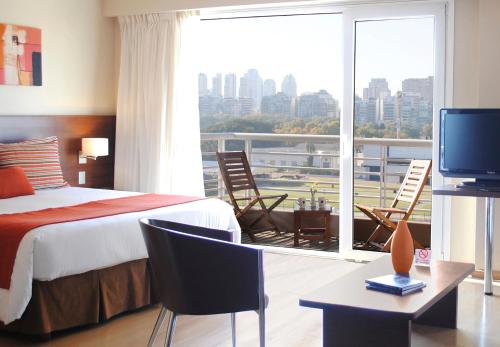 ブエノスアイレスにあるPalermo Suites Buenos Aires Hotel & Apartmentsのベッドルーム1室(ベッド1台付)、バルコニー(テレビ付)